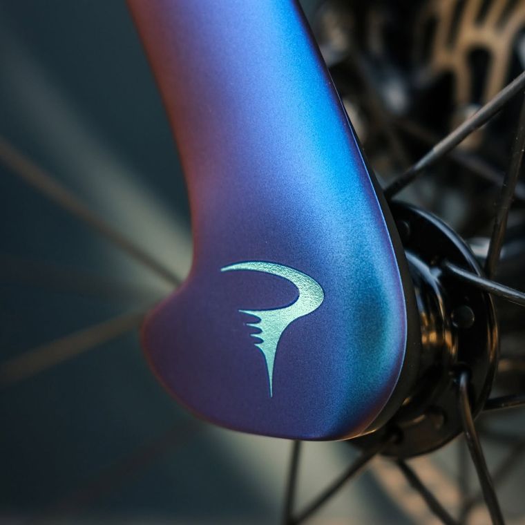 Iridescent paint shifting from blue to violet across a fork crown